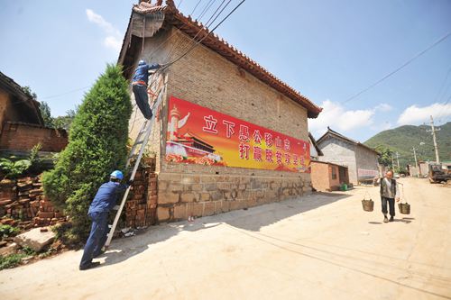 為確保濟源玉皇廟村電力供應更可靠，濟源供電公司自5月份就開始對該村電網(wǎng)升級改造，施工人員克服山高坡陡、住戶分散、室外高溫等不利條件，日夜奮戰(zhàn)在工地，目前工程已接近尾聲。圖為7月20日，該公司人員正在接村民下戶線