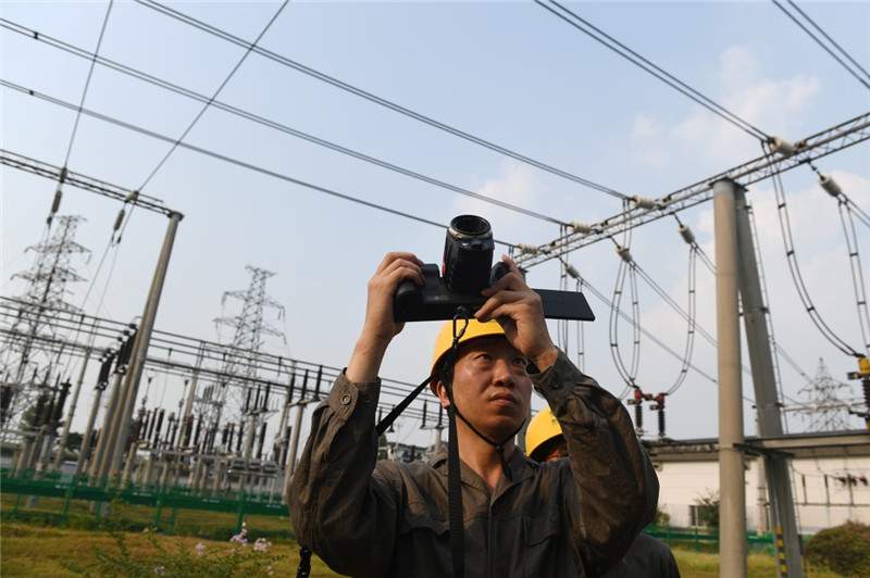 7月25日，在杭州市220千伏鳳凰變電站，運(yùn)行維護(hù)人員手持紅外熱像儀對變電站設(shè)備進(jìn)行測溫。持續(xù)的高溫天氣，促使浙江省用電負(fù)荷不斷攀升
