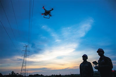 8月1日，南方電網(wǎng)海南?？诠╇娋謾C(jī)巡隊(duì)的工作人員在操作無(wú)人機(jī)巡檢?？诔菂^(qū)的電網(wǎng)線路。南方電網(wǎng)海南公司自去年開(kāi)始使用無(wú)人機(jī)巡檢輸電線路以來(lái)，該項(xiàng)巡檢工作已趨向常態(tài)化