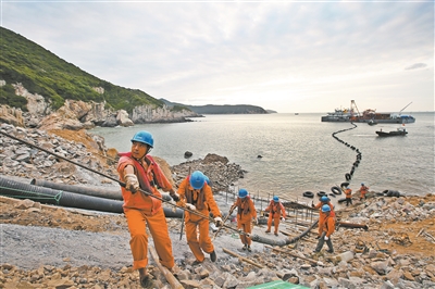 近日，用于國電舟山普陀6號海上風(fēng)電場的220千伏海底電纜首端成功登陸六橫島（見下圖）。國電舟山普陀海上風(fēng)電場工程是浙江省首個(gè)海上風(fēng)電場，該工程將敷設(shè)三條大截面220千伏光電復(fù)合電纜，路由自六橫島草盤村東岙海纜終端塔引下，向南入海敷設(shè)至海上升壓站海纜終端，單根電纜長10.3公里，預(yù)計(jì)到十月中旬完成