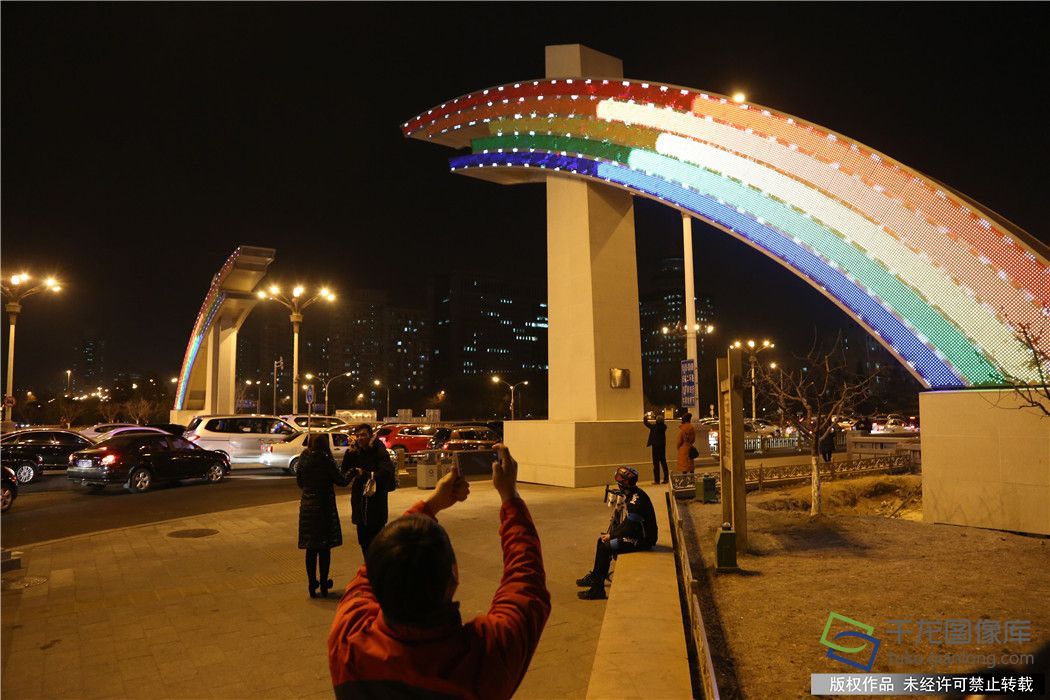 
            	2月8日農(nóng)歷臘月二十三，熄滅了75天的彩虹門重新亮燈，彩虹跨越長安街，節(jié)日的味道更濃了。晚上六點，北京長安街復興門、建國門新版彩虹橋正式點亮，紅、橙、黃、綠、藍“七彩之光”不時變換著各種狀態(tài)散發(fā)光芒，吸引了不少市民駐足欣賞，合影留念